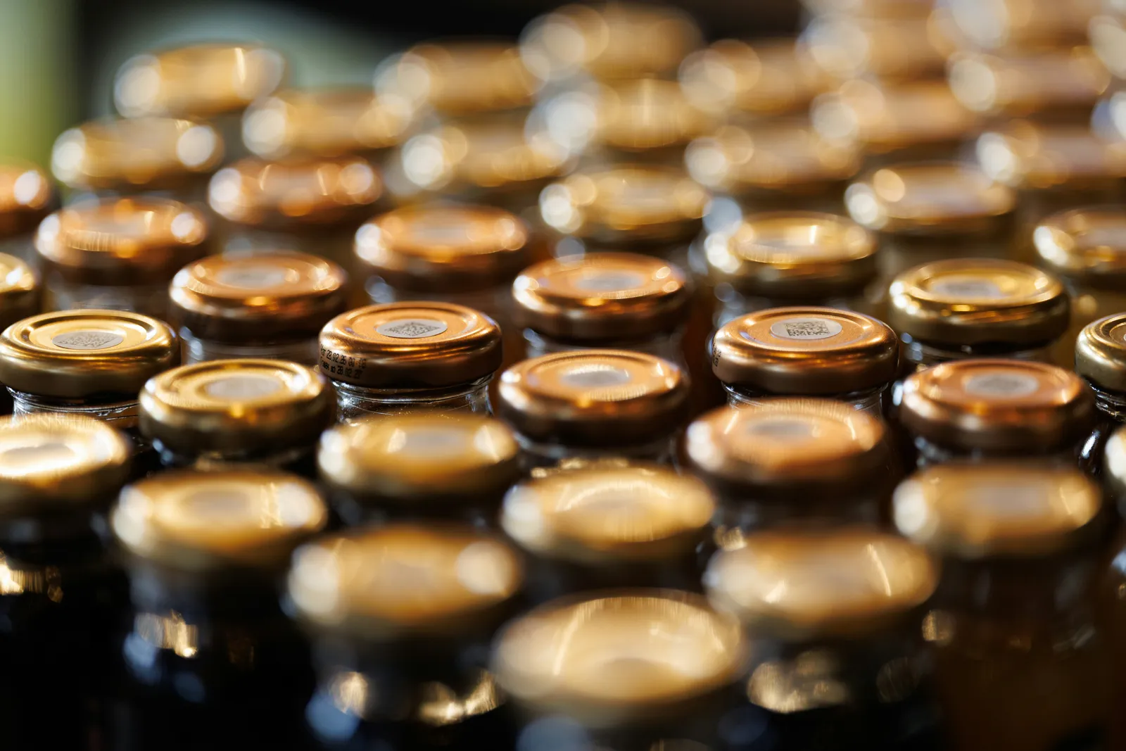 Densely packed rows of capped amber glass bottles staged for handling — specialty pallets built for glass containers.