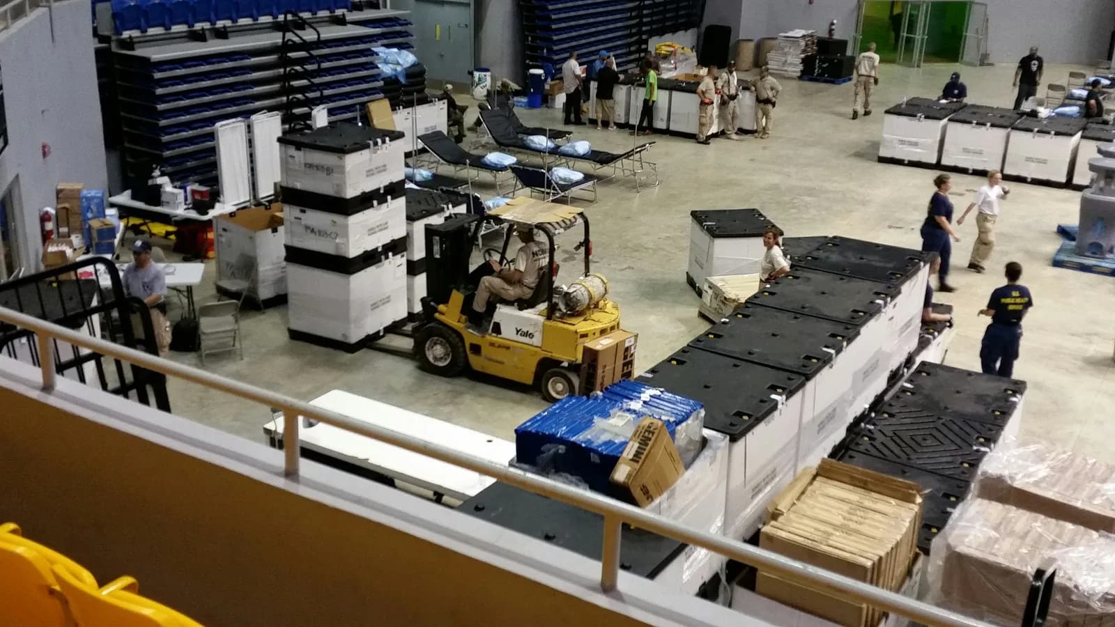 Forklift staging palletized federal supply crates in a government logistics operation — spec-built pallets for federal and military procurement.