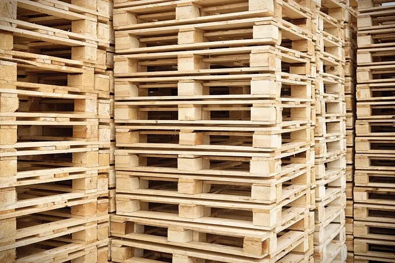 Stack of clean new wooden block pallets in bright studio lighting.