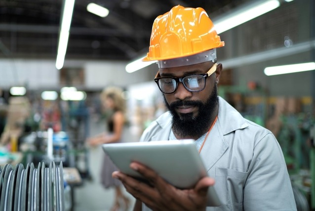 man holding tablet in manufacturing facility